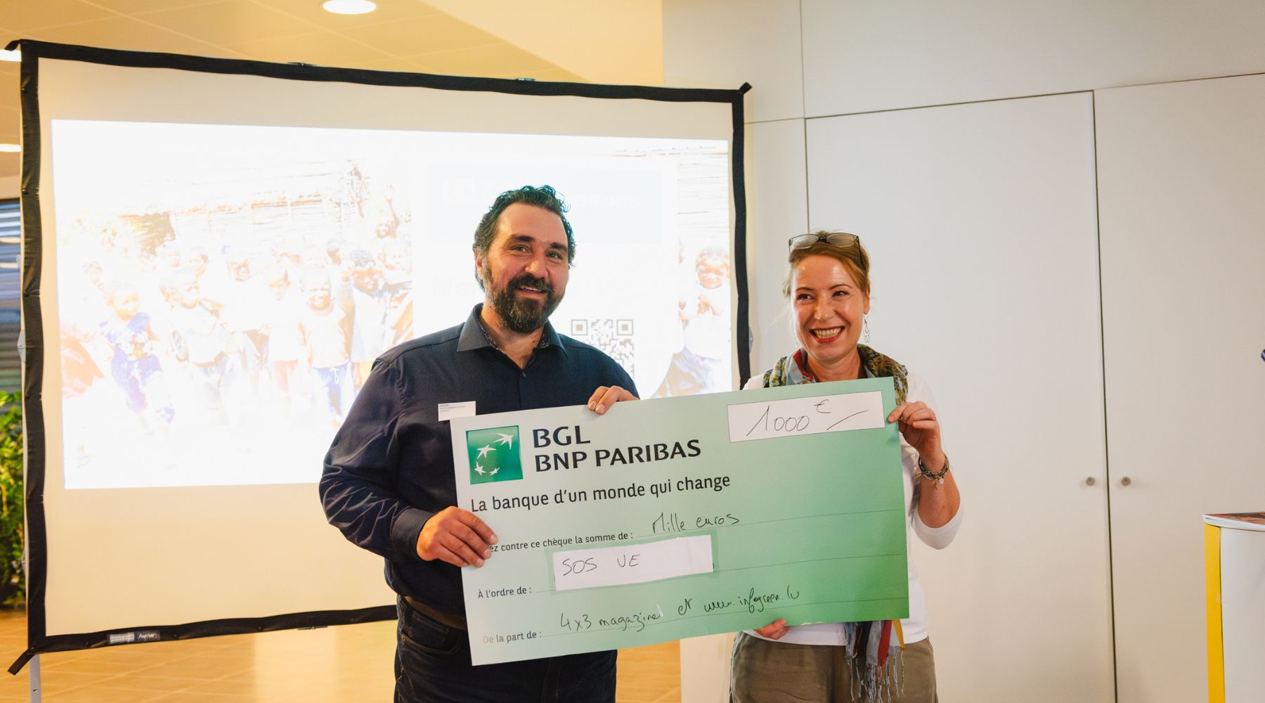 Frédéric Liegeois remet le chèque de 1000€ à Anne Schweizer, Responsable Partenariats pour SOS Villages d'Enfants Monde
