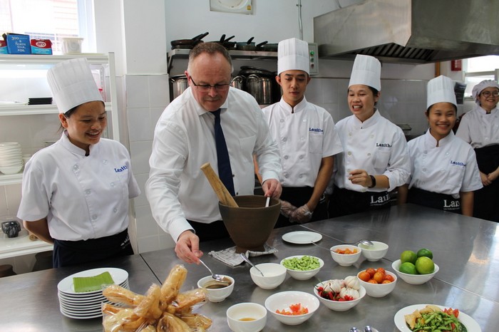 Romain Schneider, ministre de la Coopération et de l'Action humanitaire entouré de jeunes laotiens suivant une formation à l'Institut national