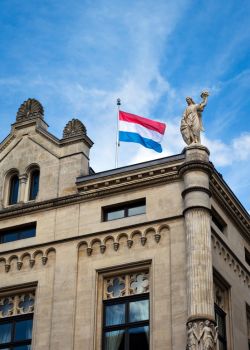 un drapeau luxembourgeois flotte dans un ciel bleu