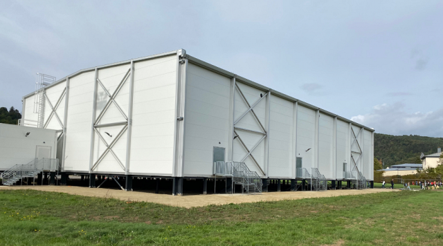 Un hall des sports en zone inondable : surélevé avec un vide pour laisser passer l'eau